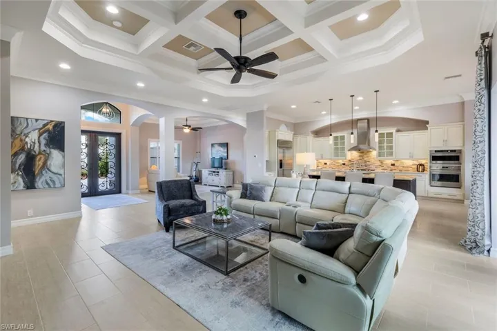 Living room with beamed ceiling, ornamental molding, and coffered ceiling