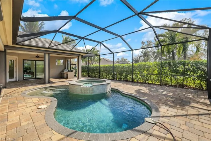 View of swimming pool with a lanai, ceiling fan, a patio, and an in ground hot tub
