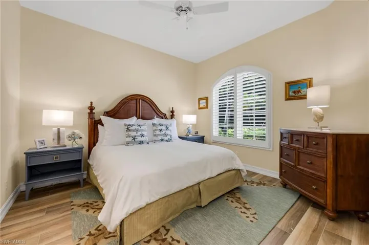 The front ensuite guest bedroom is bright and cheery with wood floors.