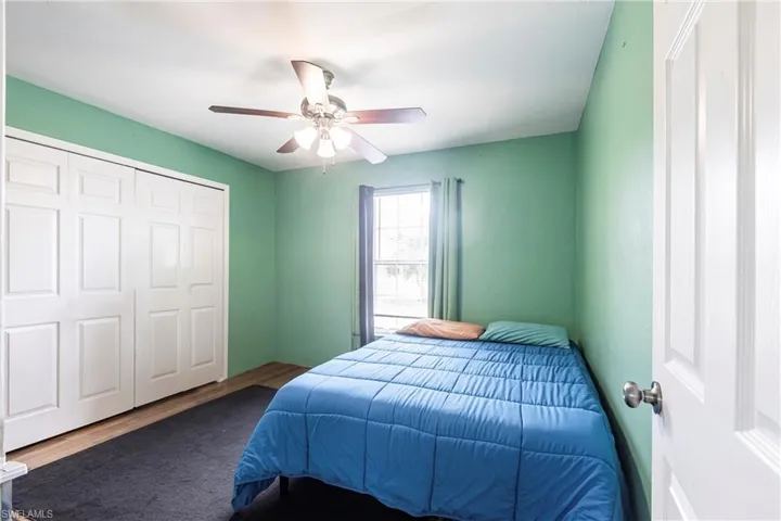 Bedroom with wood finished floors, a closet, and a ceiling fan