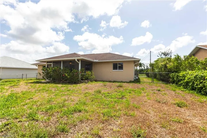 Back of property with stucco siding, a sunroom, and a ceiling fan