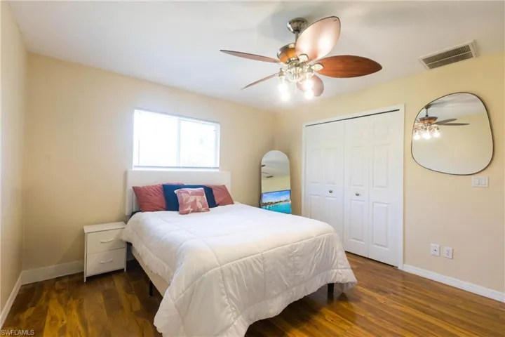 Bedroom featuring baseboards, wood finished floors, a closet, and a ceiling fan