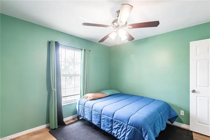 Bedroom with baseboards, wood finished floors, and ceiling fan