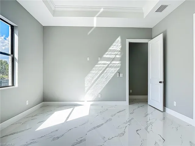 Empty room featuring light marble finish flooring and ornamental molding