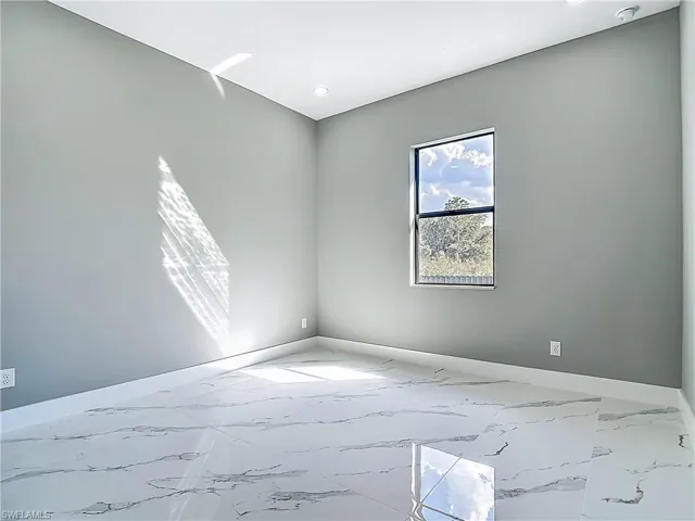 Empty room featuring baseboards and light marble finish flooring