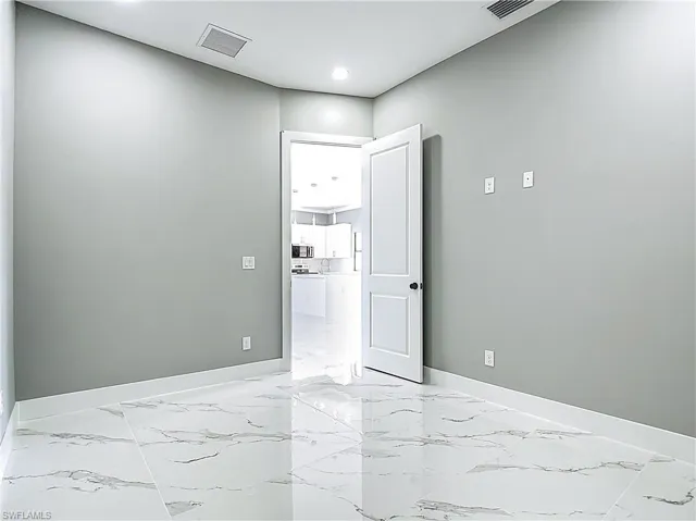 Unfurnished room featuring light marble finish flooring and recessed lighting