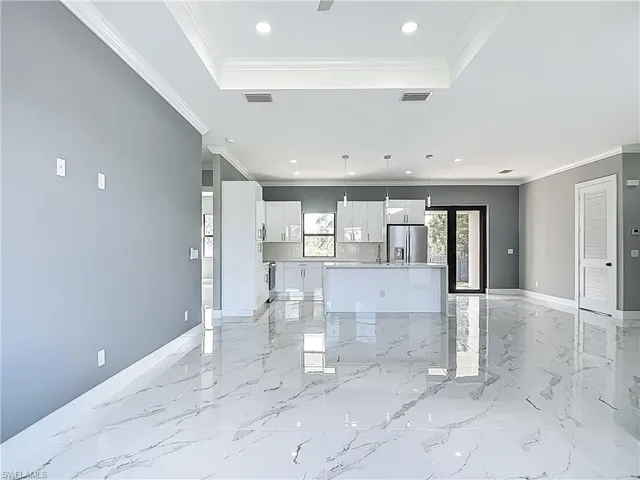 Unfurnished living room featuring recessed lighting and ornamental molding