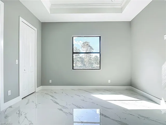 Unfurnished bedroom featuring crown molding and light marble finish floors