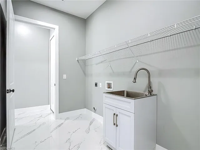 Laundry room with washer hookup, light marble finish flooring, and hookup for an electric dryer