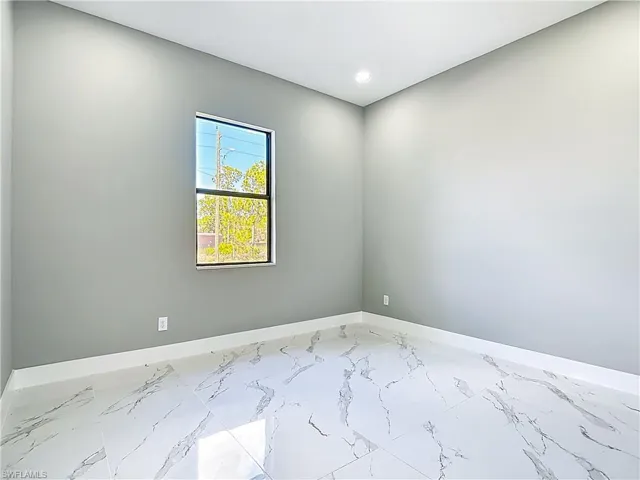 Empty room with light marble finish flooring and recessed lighting