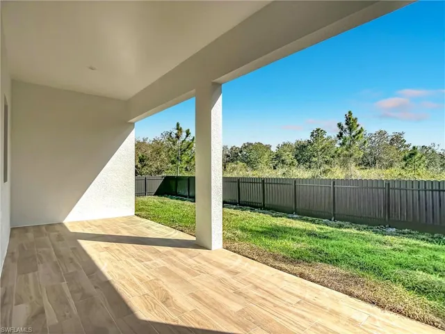 Wooden deck with a patio area and a fenced backyard