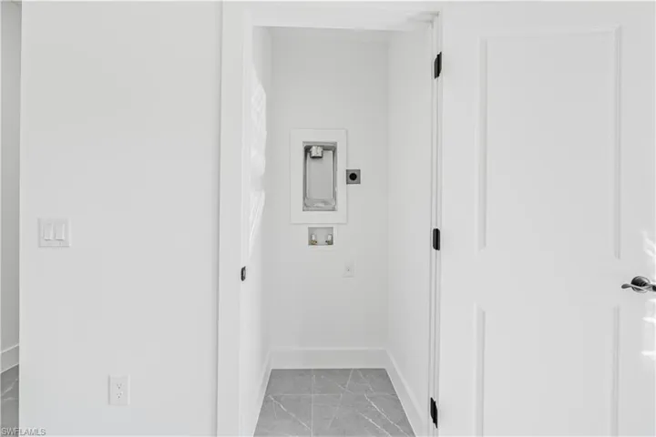Laundry area with washer hookup, light marble finish floors, and hookup for an electric dryer