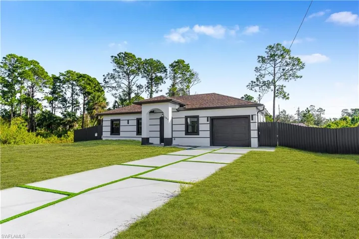 View of front of house featuring driveway, a garage, and stucco siding