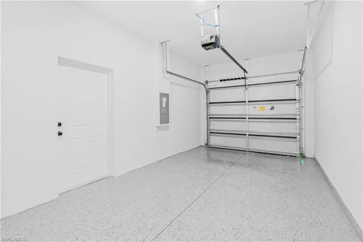 Garage featuring electric panel and a garage door opener