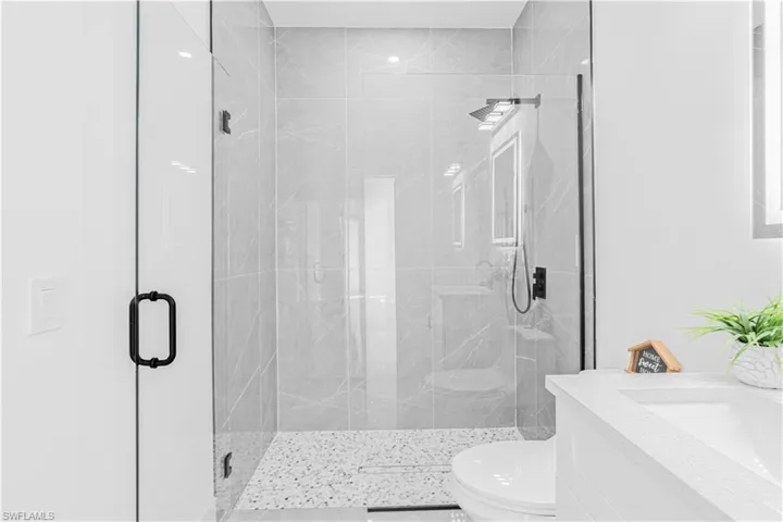 Bathroom with vanity and a marble finish shower