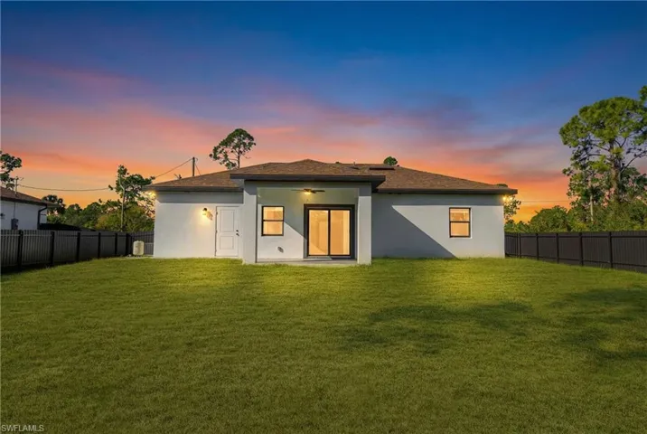 Rear view of house with a fenced backyard, a patio, and stucco siding