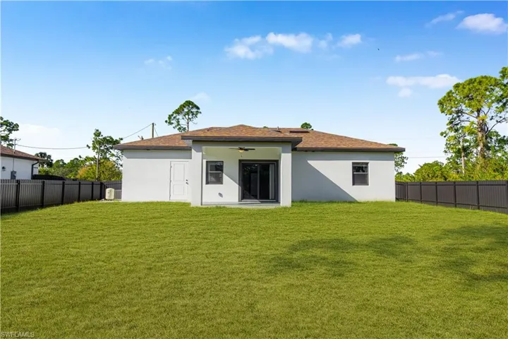 Rear view of house featuring a fenced backyard, ceiling fan, stucco siding, and a patio area