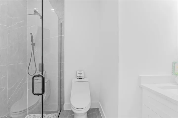 Full bath featuring vanity and a marble finish shower