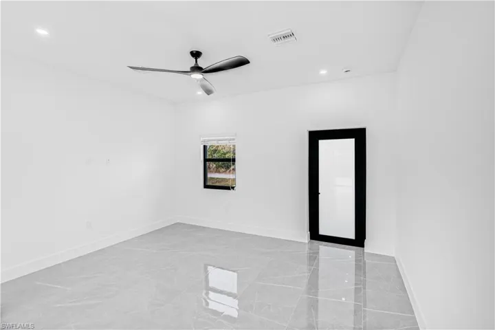 Unfurnished room featuring light marble finish flooring, ceiling fan, and recessed lighting