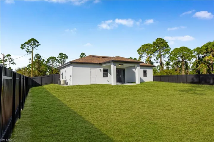 Back of property with a fenced backyard, a patio, stucco siding, and a ceiling fan
