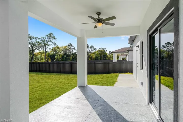 Fenced backyard featuring a patio and a ceiling fan