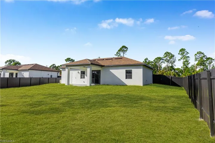 Rear view of property featuring a fenced backyard and stucco siding