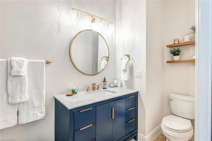 Bathroom with toilet, vanity, and tile patterned flooring
