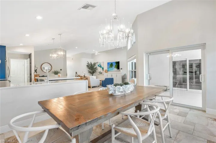 Tiled dining space featuring a notable chandelier and high vaulted ceiling