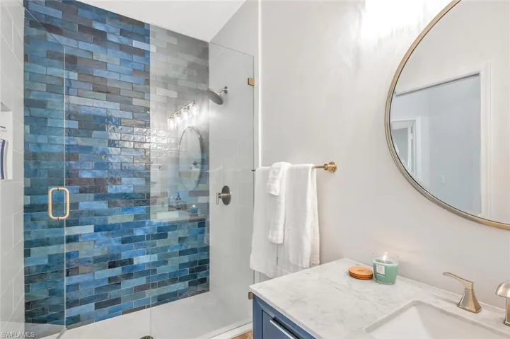 Bathroom featuring an enclosed shower and vanity
