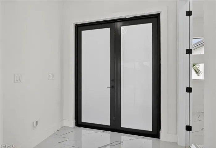 Doorway to outside featuring french doors and marble look tiles