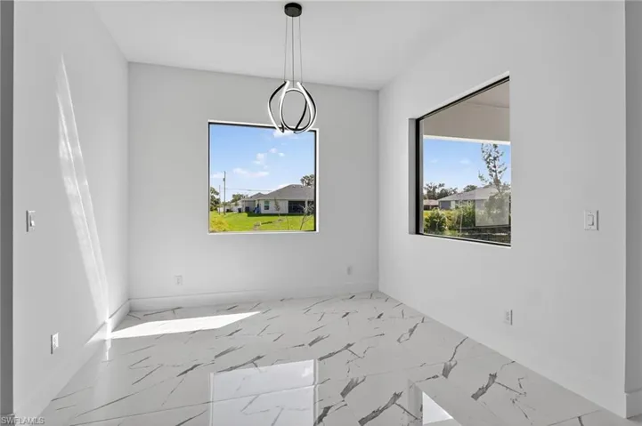 Unfurnished dining area featuring healthy amount of natural light and marble finish floors