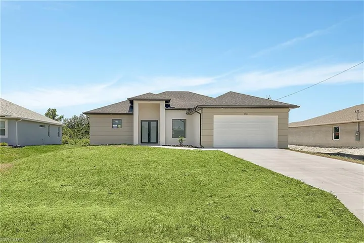 View of front of house featuring a garage and a front lawn
