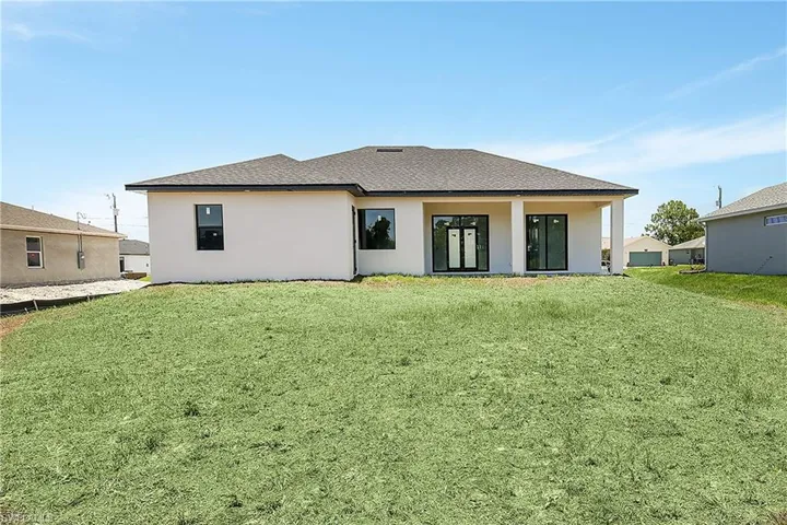 Rear view of property with a yard
