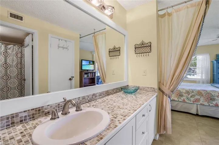 Bathroom with vanity, a textured ceiling, and tile patterned flooring