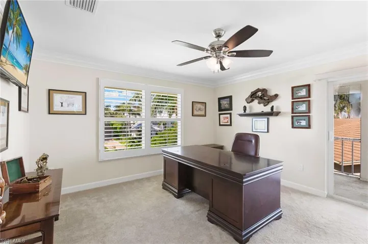 Home office with light colored carpet, crown molding, and a ceiling fan