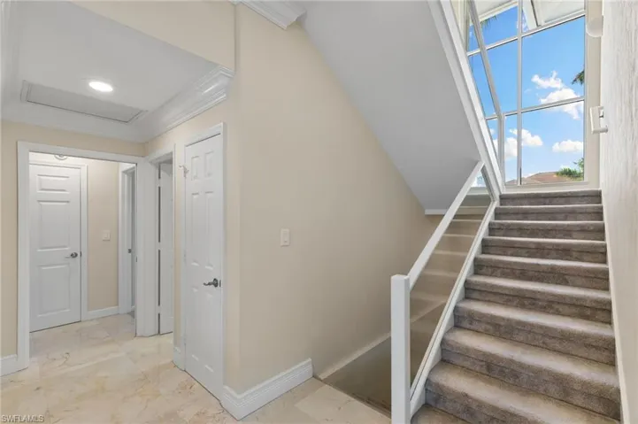 Stairs with crown molding and attic access
