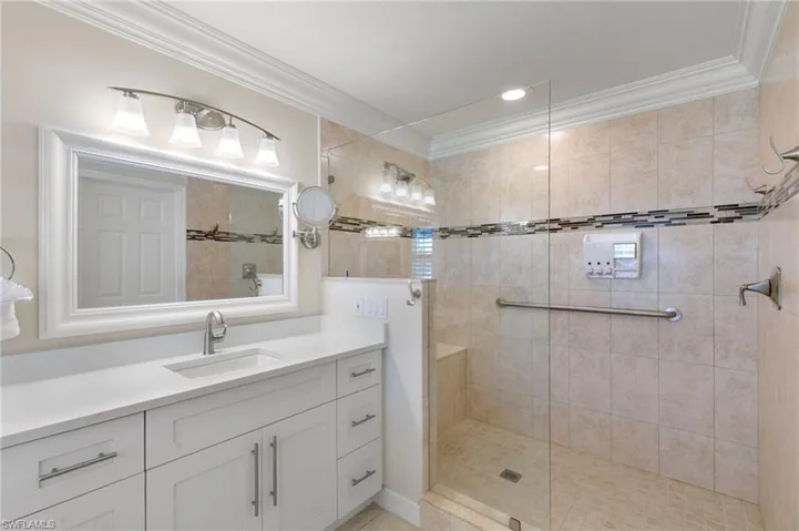 Full bathroom with vanity, crown molding, a walk in shower, and recessed lighting