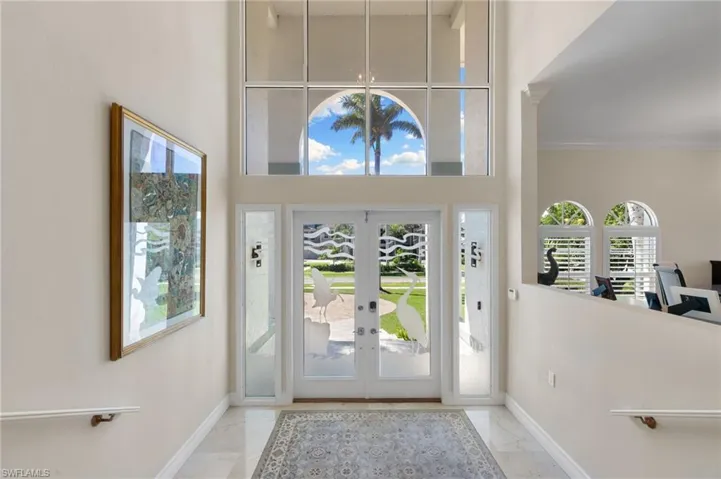 Foyer entrance featuring french doors and light marble finish floors