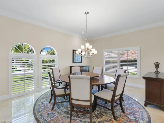 Dining room featuring crown molding and a chandelier