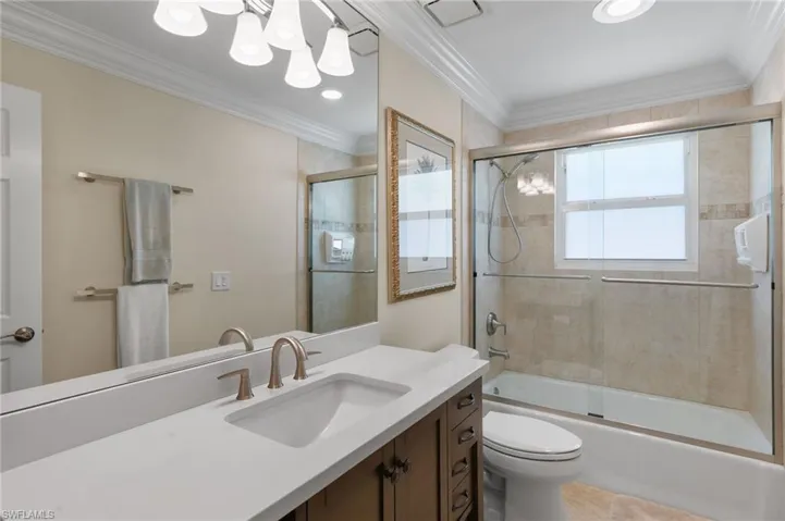 Full bath featuring combined bath / shower with glass door, vanity, crown molding, recessed lighting, and tile patterned flooring