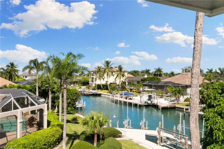 Dock area featuring boat lift, a water view, a sunroom, and glass enclosure