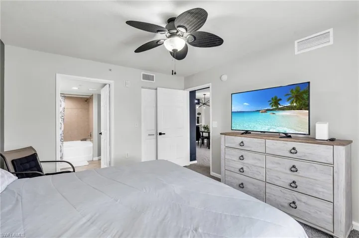 Bedroom with ceiling fan, carpet flooring, a closet, and connected bathroom