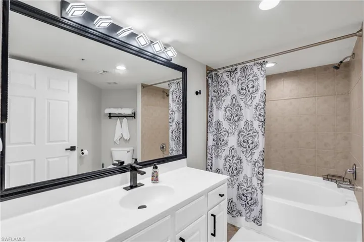 Full bathroom featuring toilet, shower / bath combo, and vanity