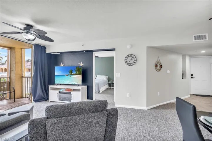 Carpeted living room featuring ceiling fan