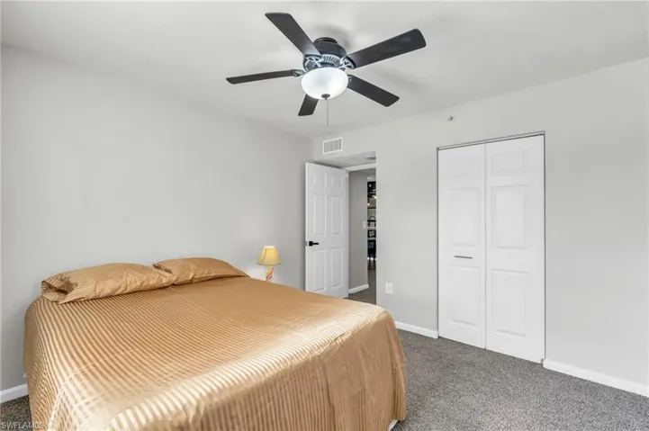 Bedroom featuring ceiling fan, a closet, and dark colored carpet