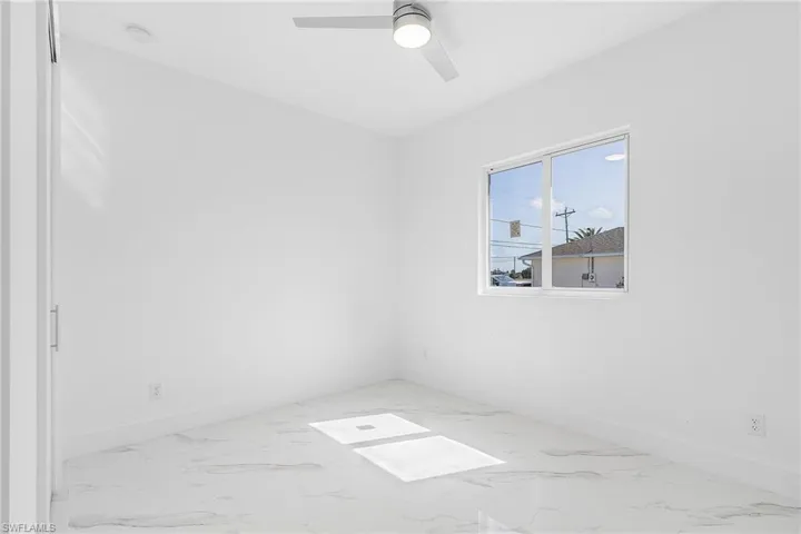 Spare room with baseboards, a ceiling fan, and marble finish floor
