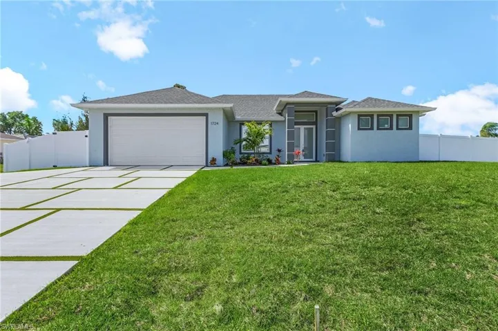 Prairie-style home with driveway, a front lawn, a garage, and stucco siding