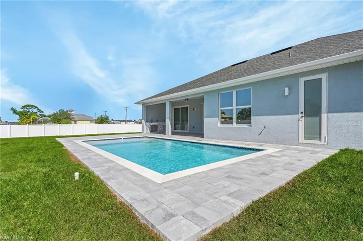 View of pool featuring a yard, a ceiling fan, a patio area, fence, and a fenced in pool