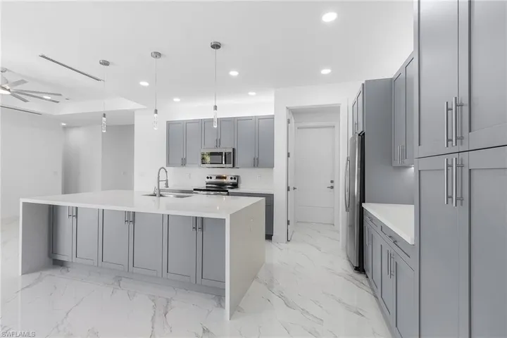 Kitchen featuring a sink, gray cabinetry, recessed lighting, and stainless steel appliances