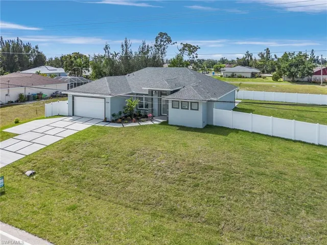 View of front of home with a garage, roof with shingles, fence, a front lawn, and concrete driveway